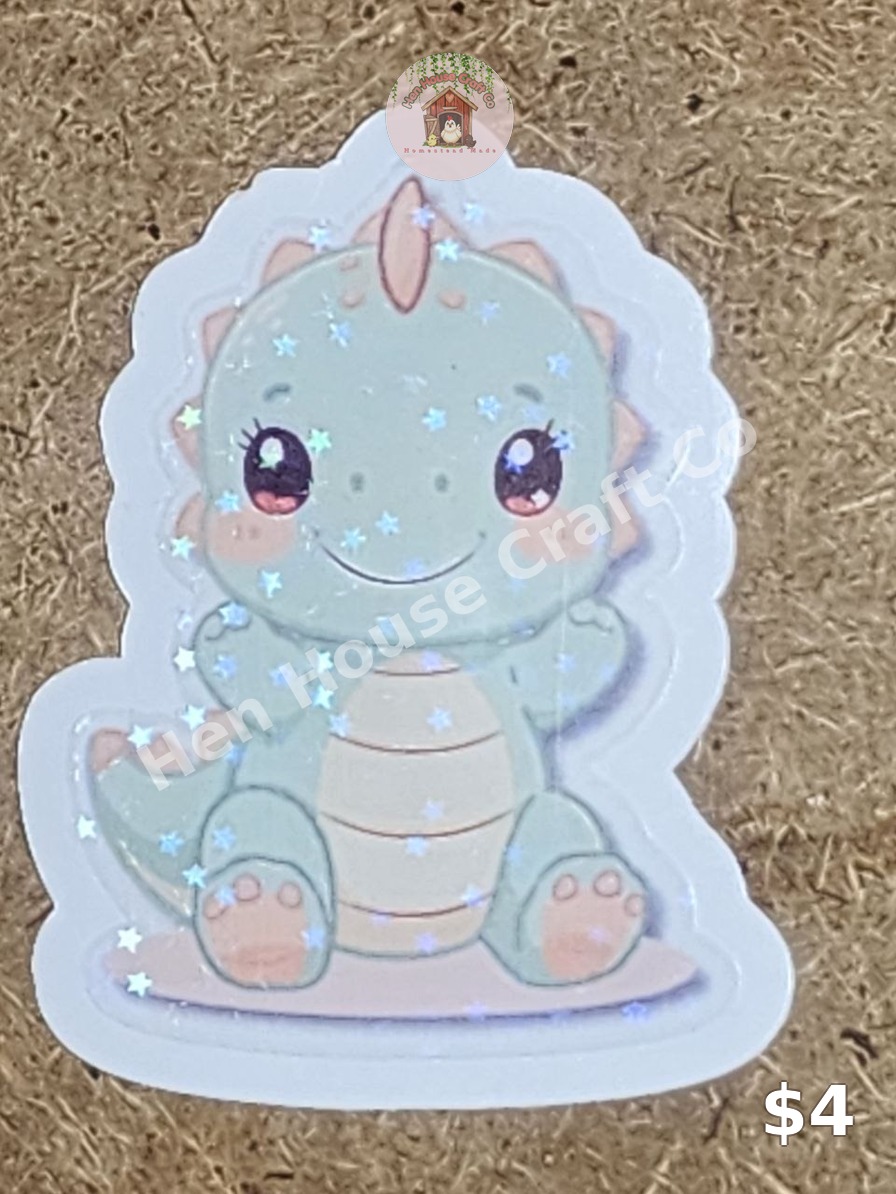 Holographic baby dinosaur sticker in soft sage green with sparkling star laminate